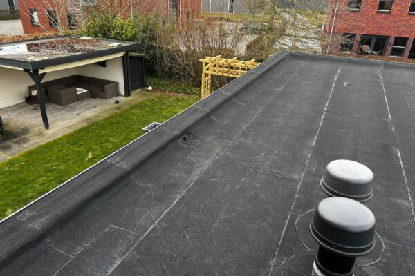 Plat dak voorzien van nieuw dakleer rond de bestaande dakdoorvoeren