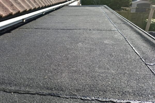 Uitgevlakt deel van dak overlaagd met nieuwe bitumen toplaag