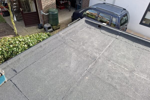 Uitbouw aan woning met de nieuwe bitumen toplaag rond de hemelwateruitloop