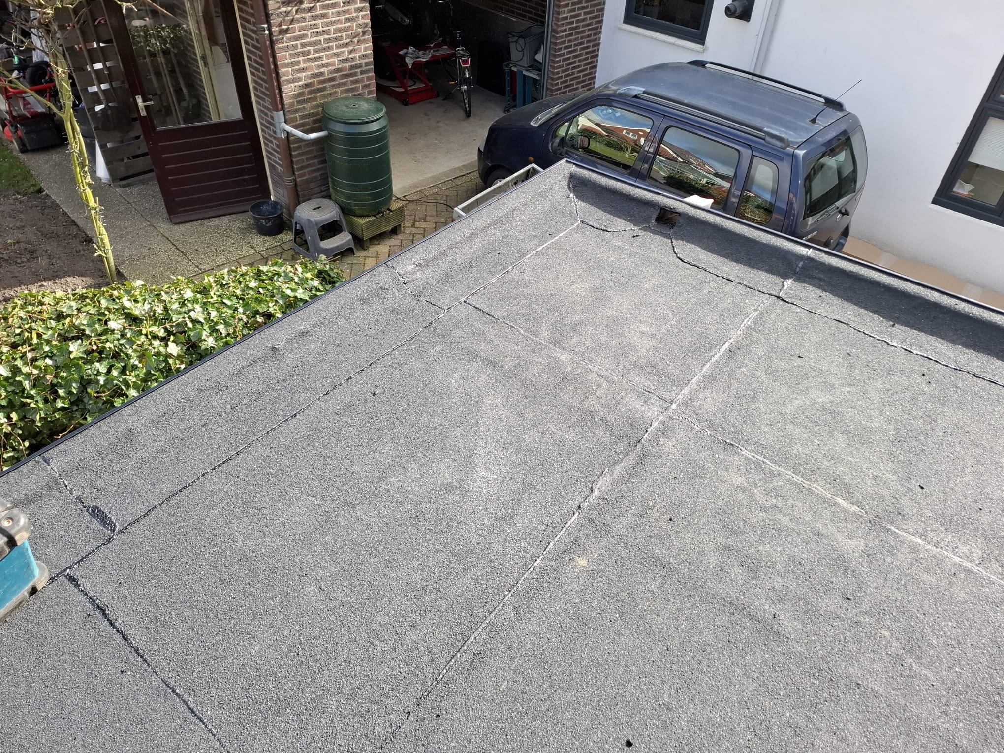 Uitbouw aan woning met de nieuwe bitumen toplaag rond de hemelwateruitloop