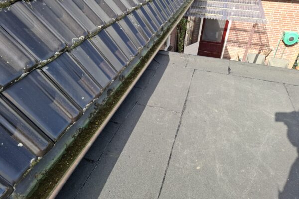 Uitbouw aan woning met de nieuwe bitumen toplaag onder de dakgoot