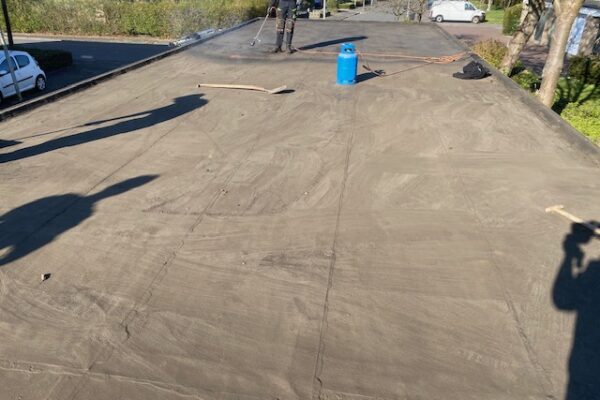 Het bestaande dak van een gemeenschappelijke carport vrijgemaakt van grind.