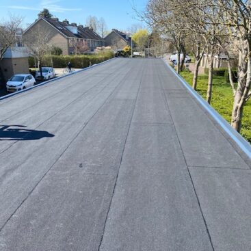het nieuwe bitumen dak van een carports afgewerkt met een aluminium afdeklijst