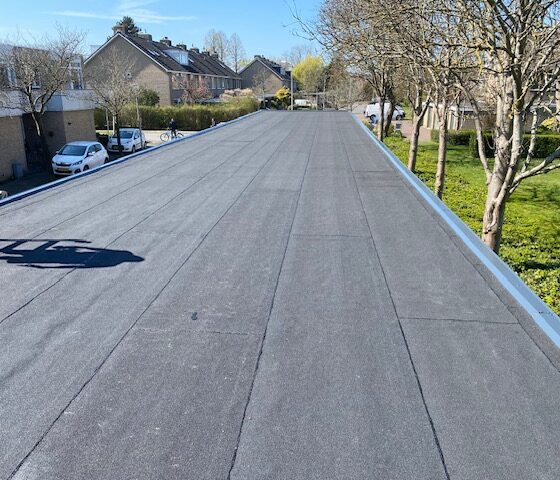 het nieuwe bitumen dak van een carports afgewerkt met een aluminium afdeklijst