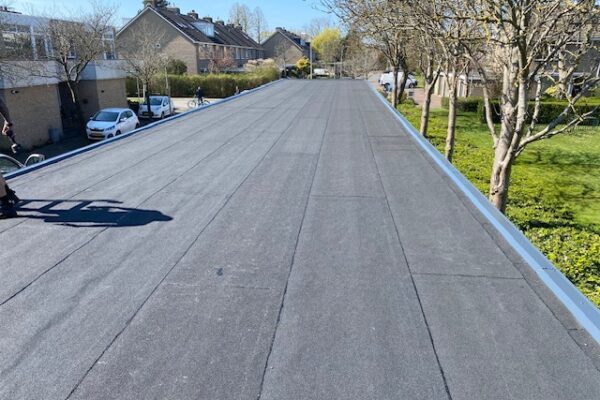 het nieuwe bitumen dak van een carports afgewerkt met een aluminium afdeklijst