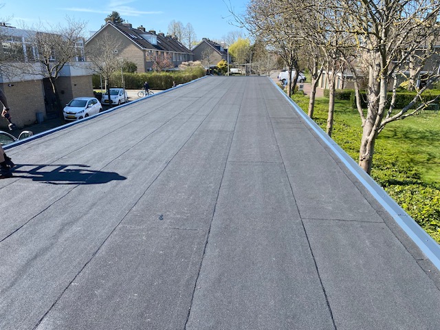 het nieuwe bitumen dak van een carports afgewerkt met een aluminium afdeklijst