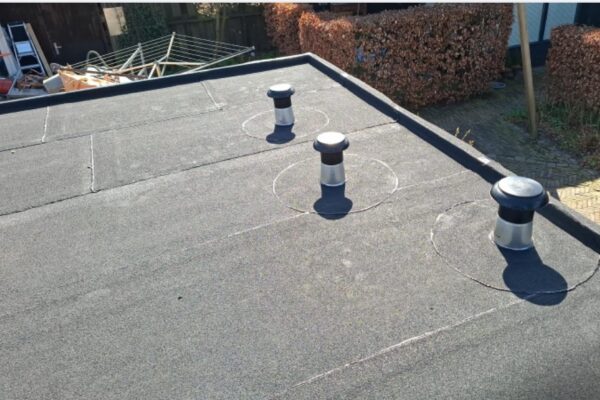 op het nieuwe bitumen dak zijn de nieuwe dakontluchtingen op het platte garagedak, fraai afgewerkt